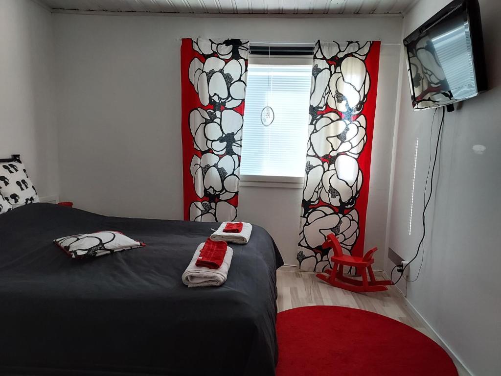 NakkilaApartment Tallitalo - Garage House的一间卧室配有黑色的床和红色地毯