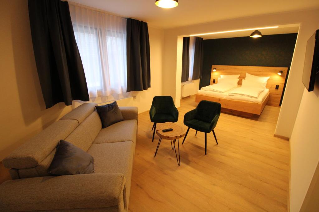 蒙绍DER Hirsch Hotel的客厅配有沙发和1张床