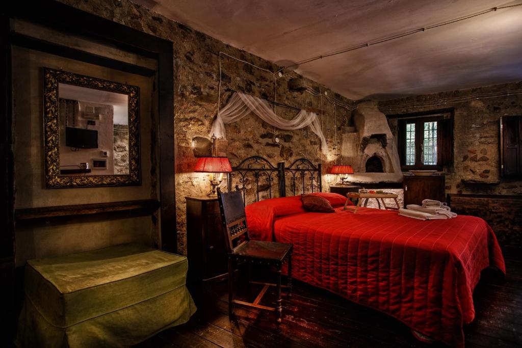 BrienzaLa Voce del Fiume Dimora di Charme的一间卧室配有红色的床和椅子