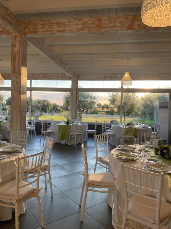BruscianoHotel Villa Ruggiero的一间设有白色桌椅的用餐室