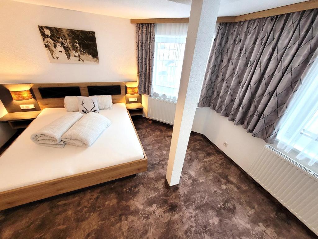 卡普尔Apart Garni Jägerheim的一间卧室设有一张床和两个窗户。
