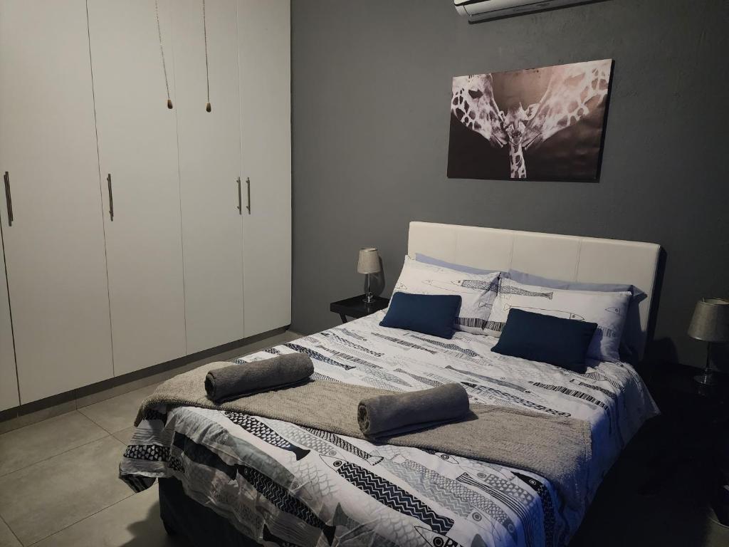 内尔斯普雷特Le Grix Guesthouse的一间卧室配有一张带蓝色枕头的床。
