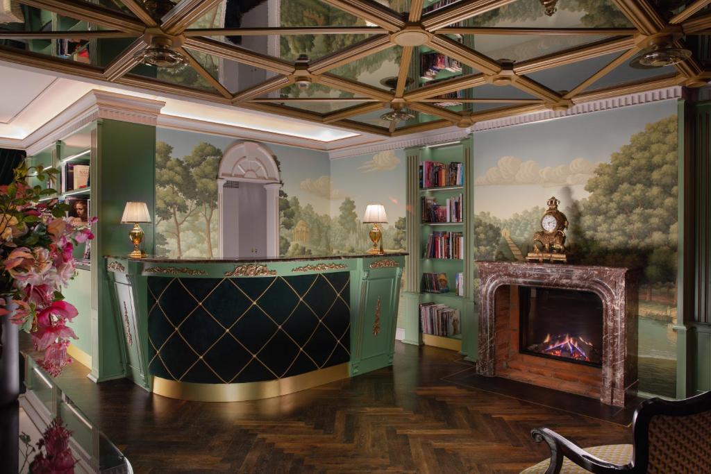 维也纳ARTIST Boutique Hotel的客厅设有壁炉和墙上的绘画作品