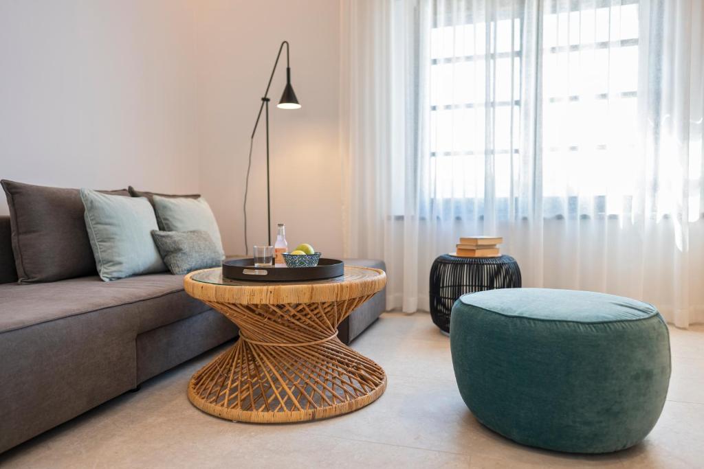 罗德镇Naillac Elite Suites的带沙发、桌子和凳子的客厅