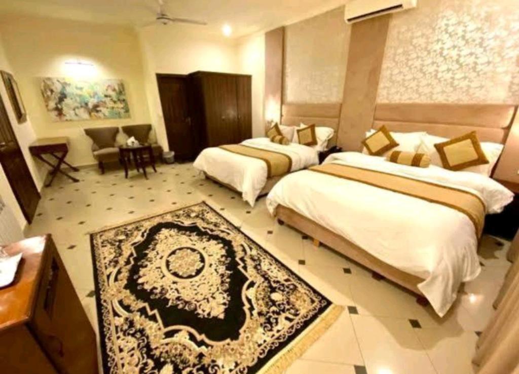 伊斯兰堡Imperial lodges的酒店客房设有两张床和一张桌子。