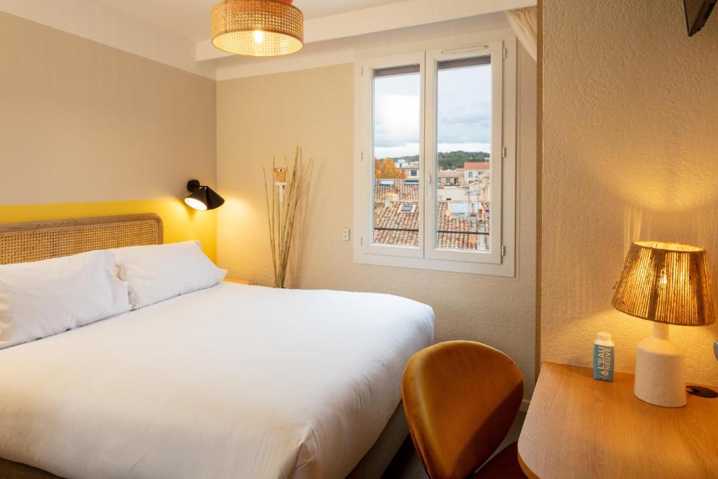 普罗旺斯艾克斯Hôtel Escaletto的卧室配有白色的床和窗户。