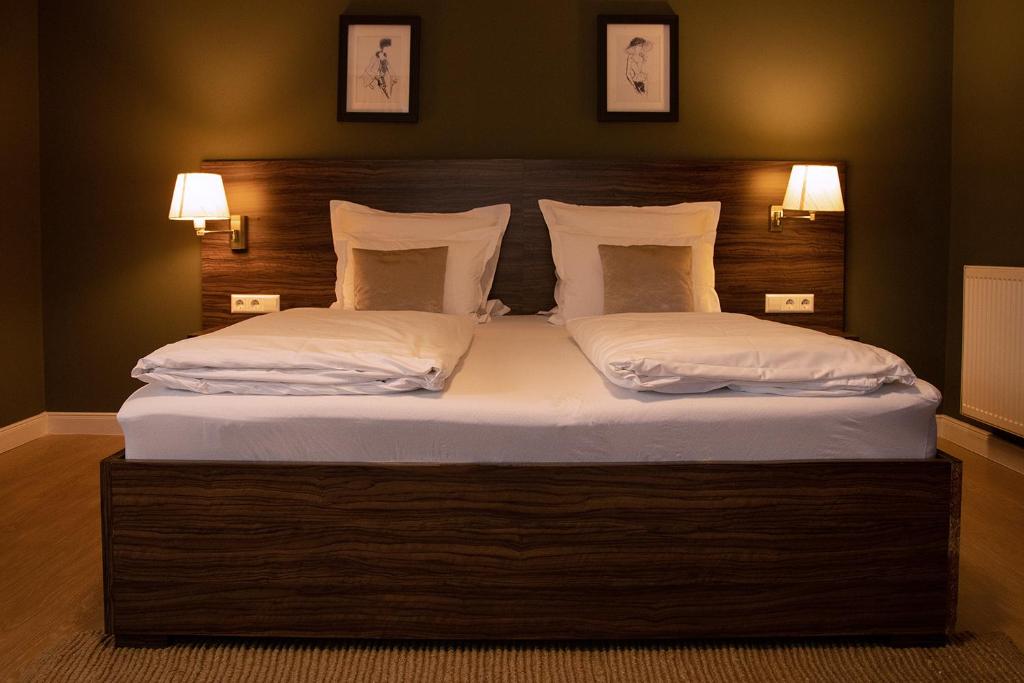 武夫斯根瓦尔德公园迎宾酒店的一间卧室配有一张带两个白色枕头的大床