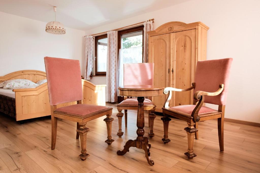 因斯布鲁克Haus Fink的卧室配有两把椅子、一张桌子和一张床