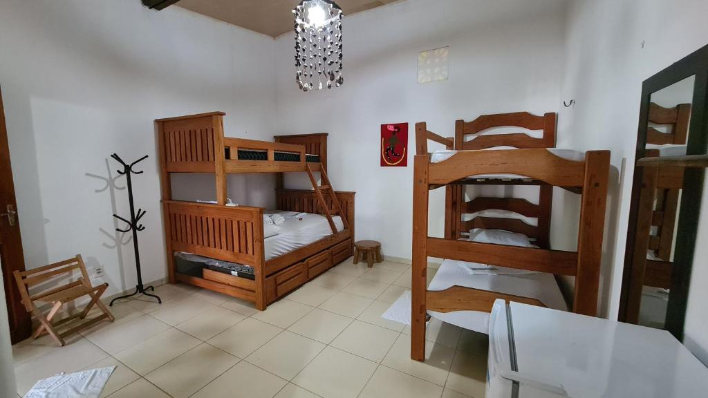 阿尔戈杜瓦尔Vila Shangri-la Algodoal- Suítes e Redário的客房设有两张双层床和一张桌子及椅子。