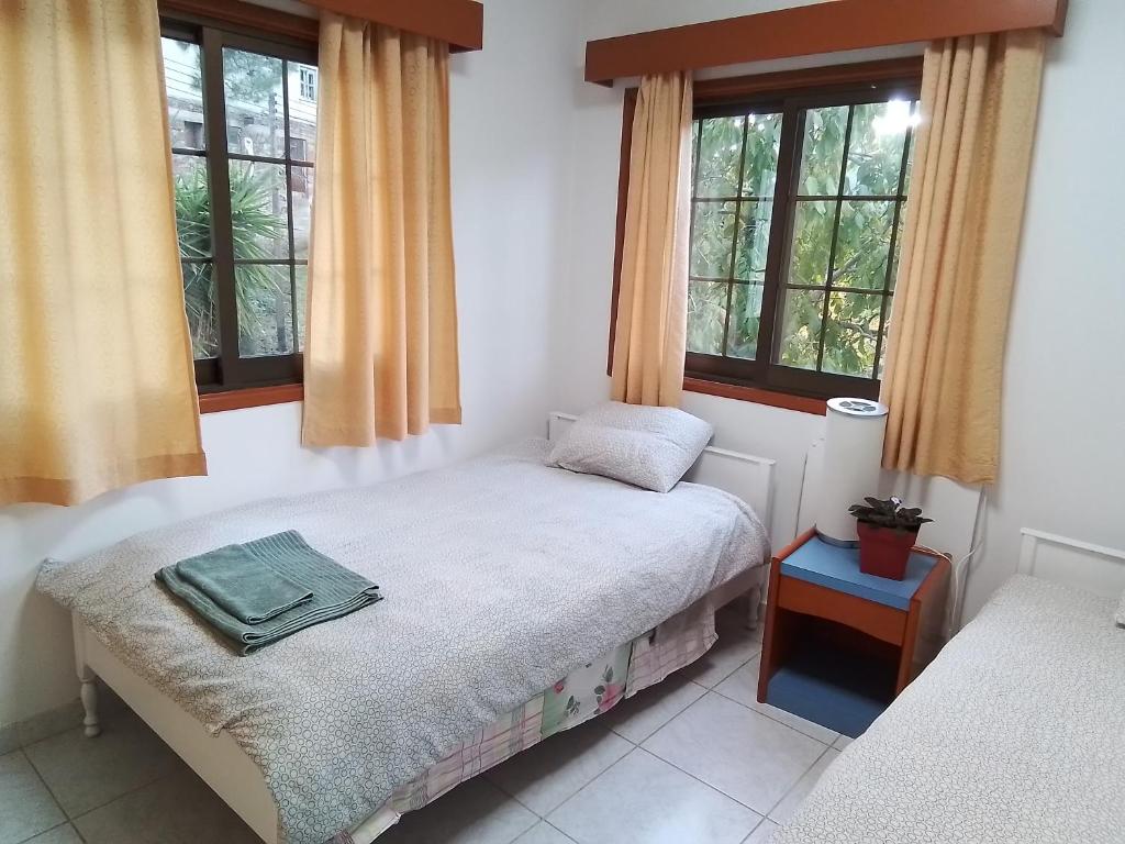 尼科西亚Kampi Double Storey House in the Village的一间卧室设有一张床和两个窗户。
