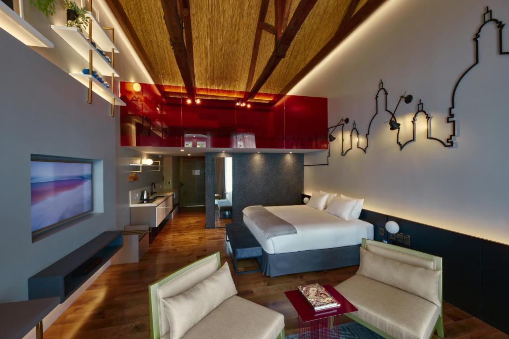 昆卡Casa Firenza Hotel & Suites Boutique的一间酒店客房,配有一张床和一台电视