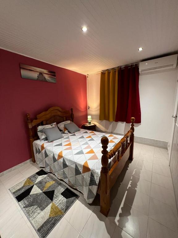 勒拉芒坦Poseidon的一间卧室配有一张木床和色彩缤纷的墙壁