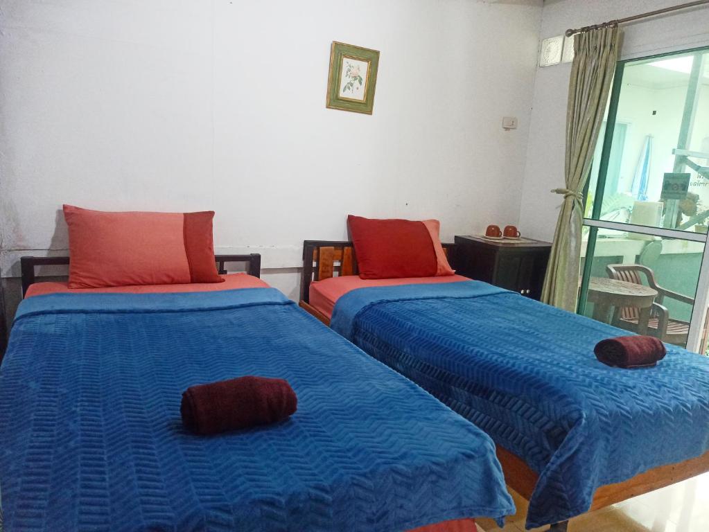 奈扬海滩Nu Phuket Airport Resident 1的蓝色和红色的客房内的两张床
