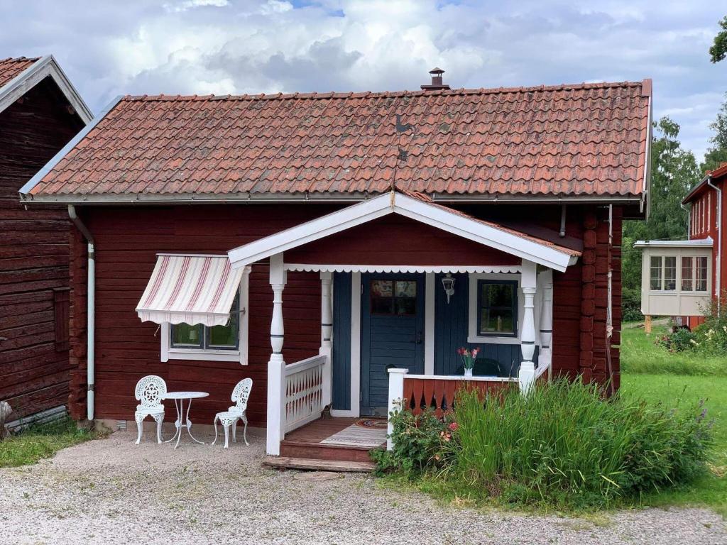 塔尔伯格Holiday home Tällberg II的一间红色的小房子,配有桌子和椅子