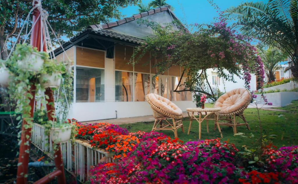 邦美蜀Vườn Pháp 3 Homestay的院子里有两把椅子和鲜花的房子