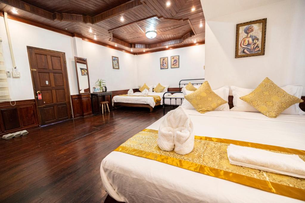 琅勃拉邦Mekong Chidlatda Villa的酒店客房带两张床和一个客厅