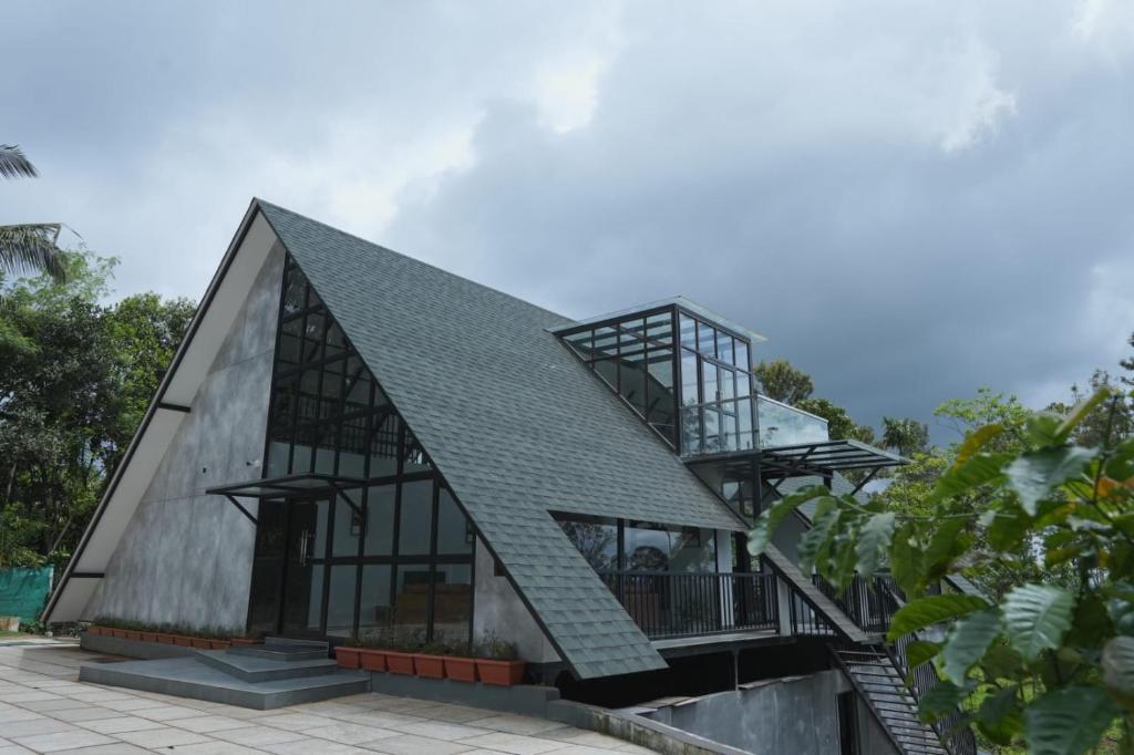 PadinjaratharaNammal Resorts的一座带金属屋顶和楼梯的房子