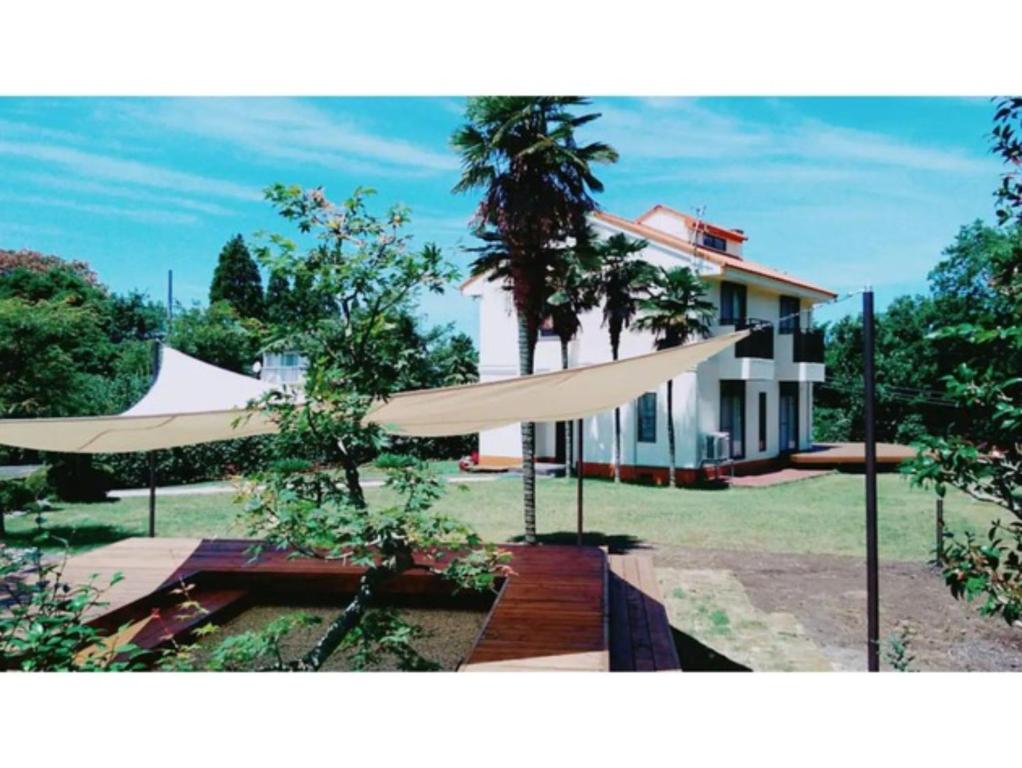 米子市Glamp House DAISEN Garden - Vacation STAY 97255v的前面有两把白色遮阳伞的房子