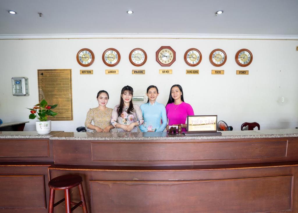 Vị ThanhKhách Sạn Bông Sen的站在柜台后面的四名妇女