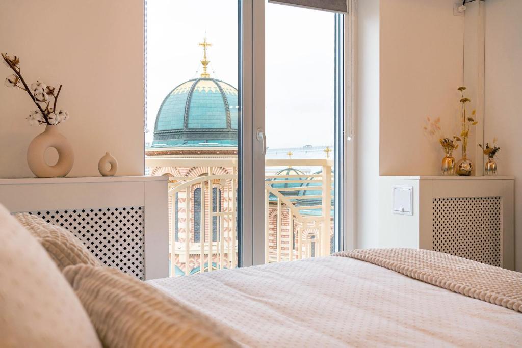 布加勒斯特Style and view Bucharest city center aparthotel的一间卧室配有一张床,享有建筑的景色