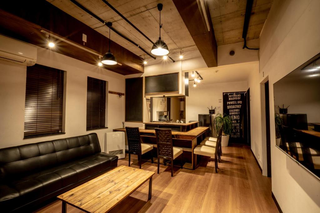 小樽IPPO生活小屋公寓式酒店的客厅配有真皮沙发和桌子
