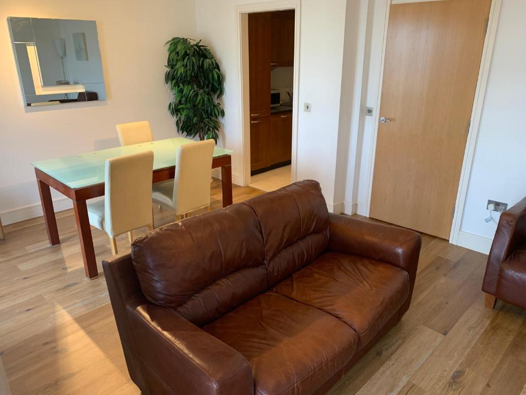 戈尔韦City Centre Apartment in Galway - 2 Bedrooms的客厅配有真皮沙发和桌子