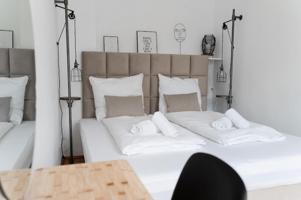杜伊斯堡JUNIK Apartments - Deine Cityapartments in Duisburg的一张配有白色床单和枕头的大床