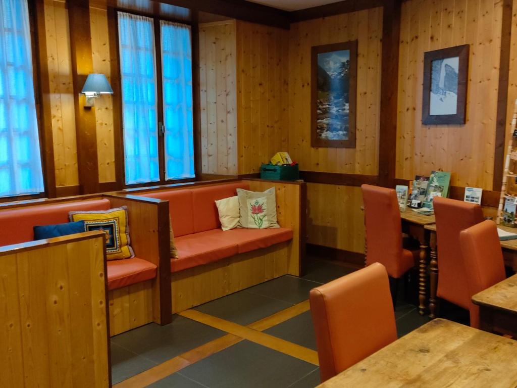 科特雷Gîte Beau Soleil的餐厅设有橙色椅子和桌子以及窗户。
