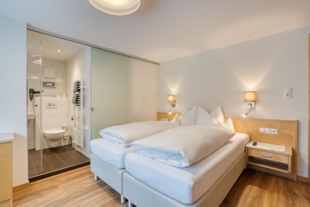 施图本阿尔贝格Landhaus Maria的白色的卧室设有一张大床和一间浴室。