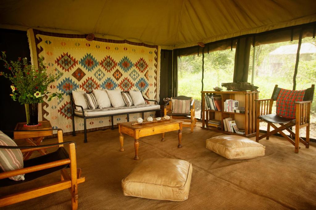 SinoniEsirai Camp的客厅配有沙发和帐篷内的椅子