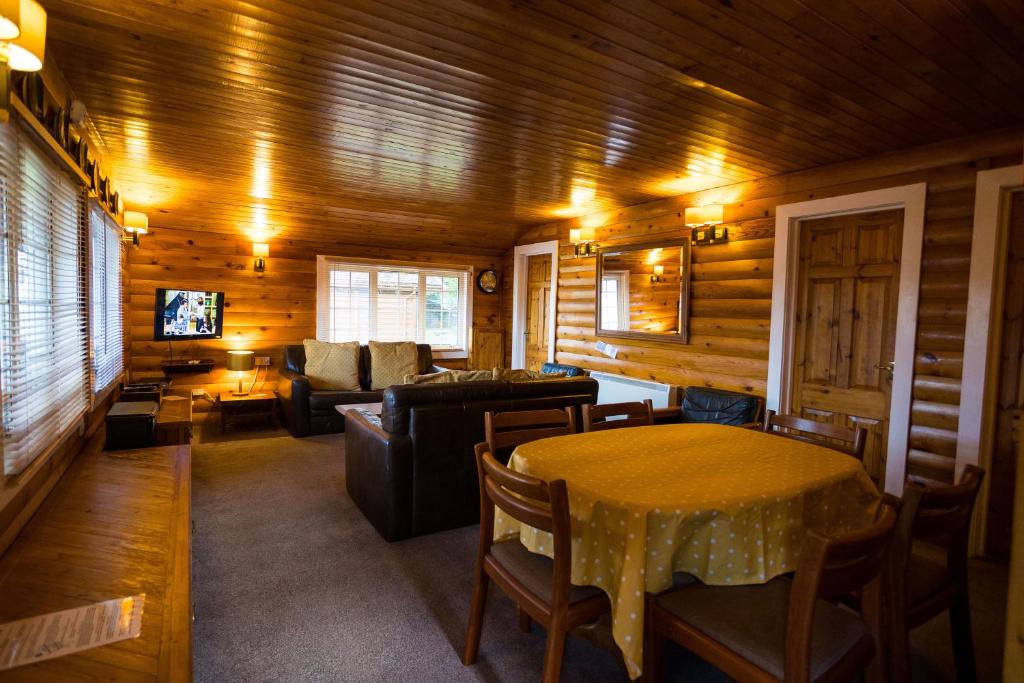 特兹西尼德Mountain View Log Cabin - Wales的客厅配有桌子和沙发