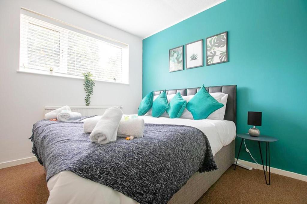 彼得伯勒Emerald House Leisure & Contractors的一间卧室配有一张带蓝色墙壁的大床