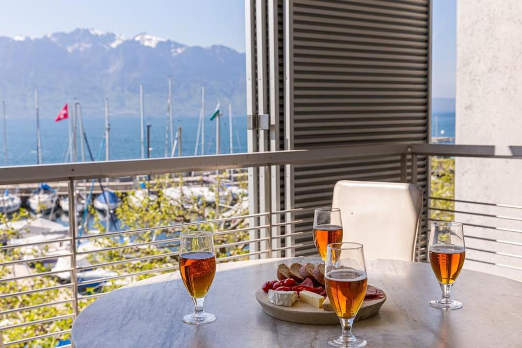 沃韦Lakeside Apartment - Grand appartement familial avec terrasses et vue panoramique的两杯酒和一盘桌上的食物