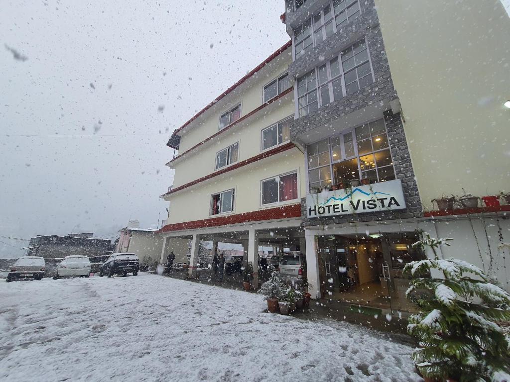 博瓦利Hotel Vista Bhowali, Nainital - Vegetarian的大楼前的雪地里的酒店