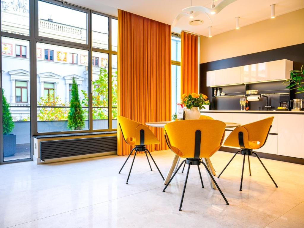罗兹Pietryna Apartments Luxury - Sauna , Jacuzzi , Bezpośrednio przy ul Piotrkowskiej的厨房配有黄色的椅子和桌子