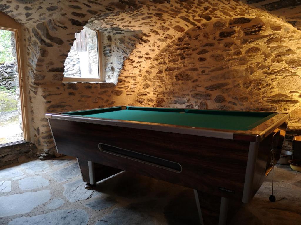PlanayLes gîtes du Mistouflon的石墙房间内的台球桌