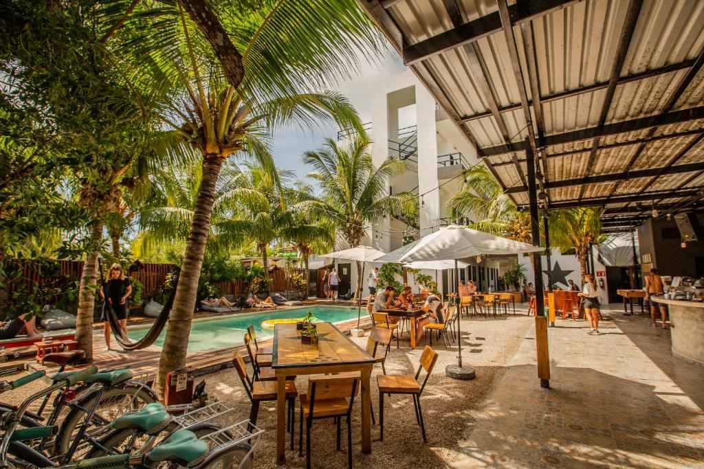 奥尔沃克斯岛Che Holbox Hostel & Bar Adults Only的一个带游泳池和桌椅的度假酒店