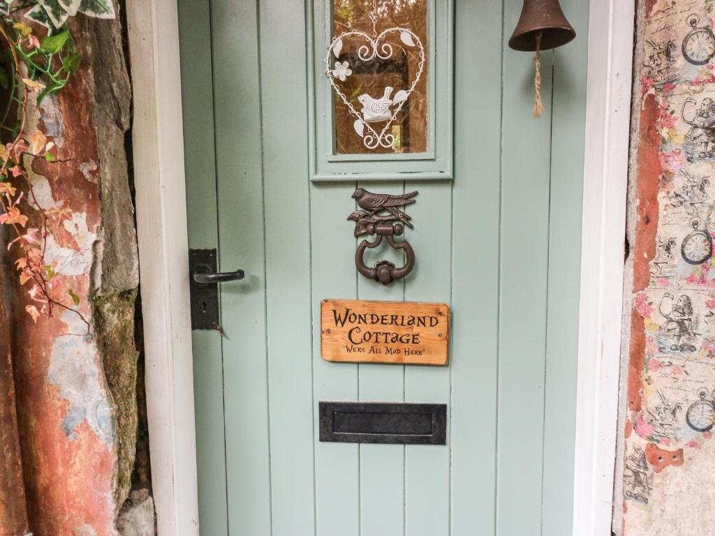 库珀Wonderland Cottage的门上挂有标志,上面有标志