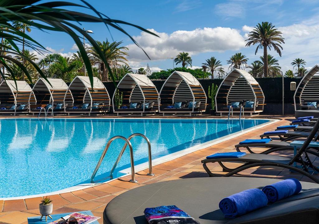 英格兰海滩Axel Beach Maspalomas - Adults Only的毗邻度假酒店的带躺椅的游泳池