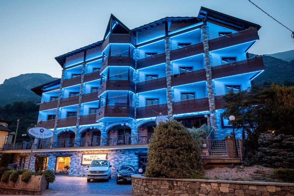 夏特林瑞蕾斯度酒店的一座蓝色的建筑,前面有汽车停放