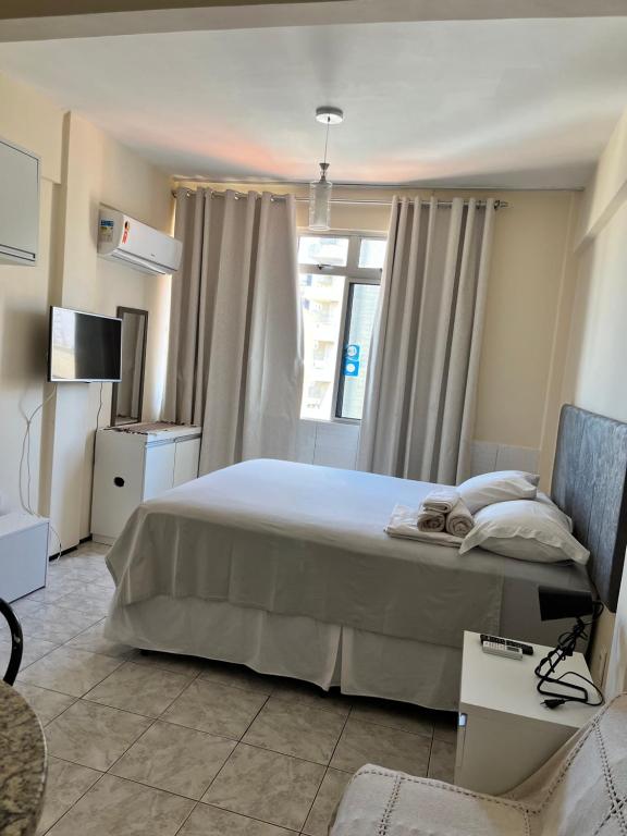 福塔莱萨Stúdio Beira Mar的一间卧室设有一张大床和一个窗户。