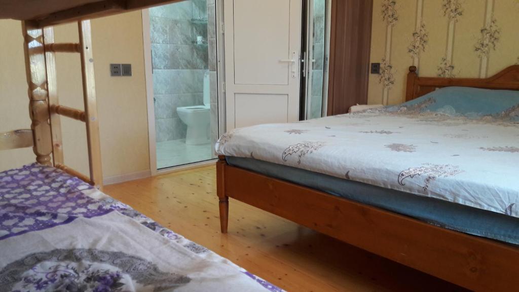巴库哈萨诺维斯别墅酒店的一间带两张床的卧室和一间带卫生间的浴室
