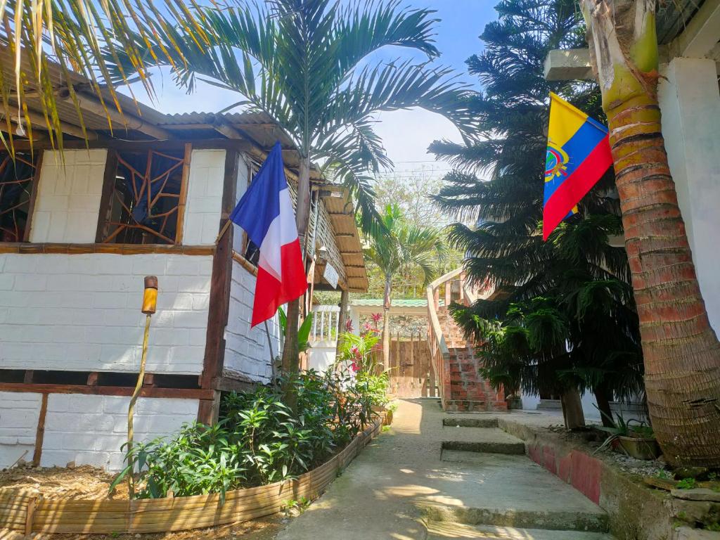 蒙塔尼塔Munay Backpacker Hostel的棕榈树房子上的两面旗