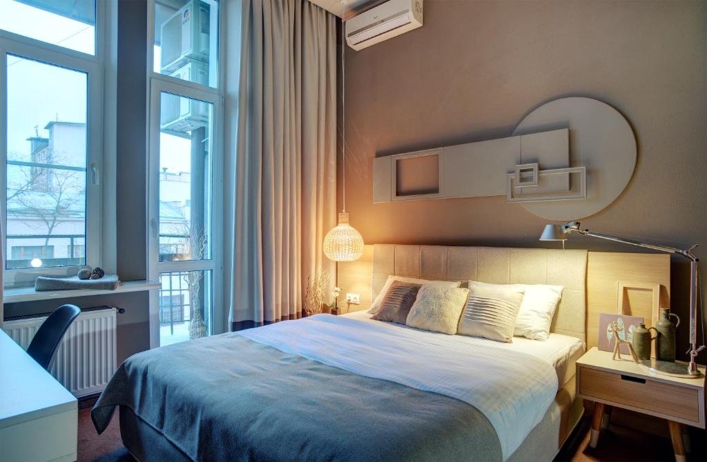 敖德萨诗人艺术酒店的卧室配有一张床、一张书桌和窗户。