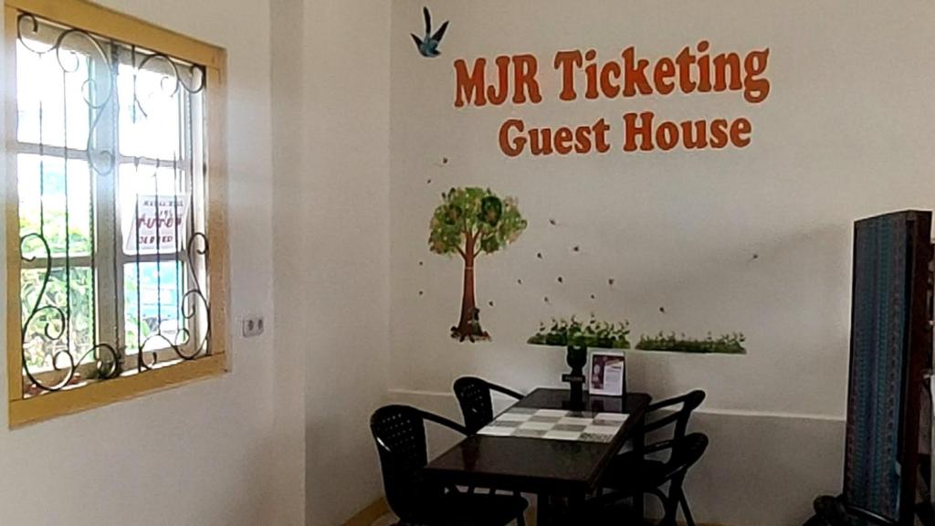 鲁滕MJR Ticketing Guest House的一间设有桌子和墙上标牌的用餐室