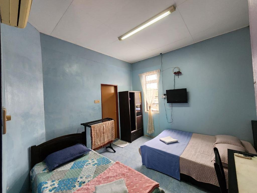 CukaiDeummah Guest Room的一间设有两张床和电视的房间