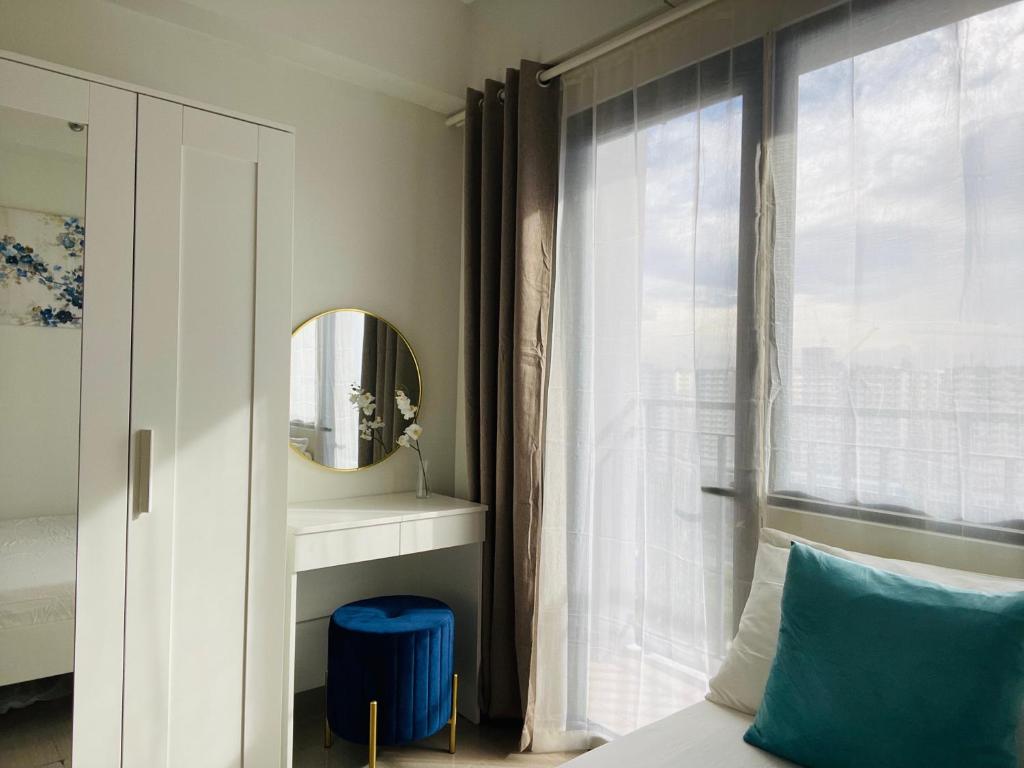 马尼拉Sakan 5-Star Quality Condotel的一间卧室配有一张床、镜子和窗户