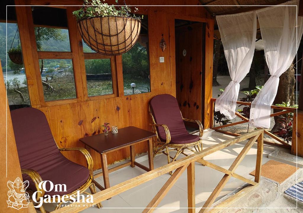 帕罗林Om Ganesha的带窗户的客房内配有两把椅子和一张桌子