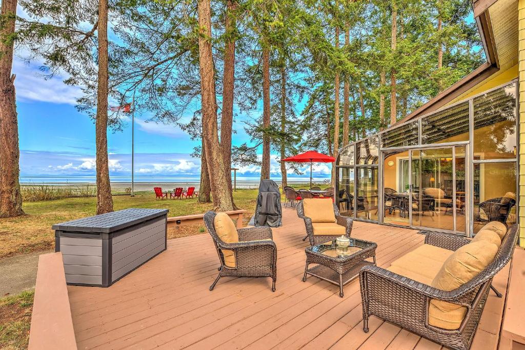 科莫克斯Kye Bay Beach House的木制甲板配有椅子和桌子