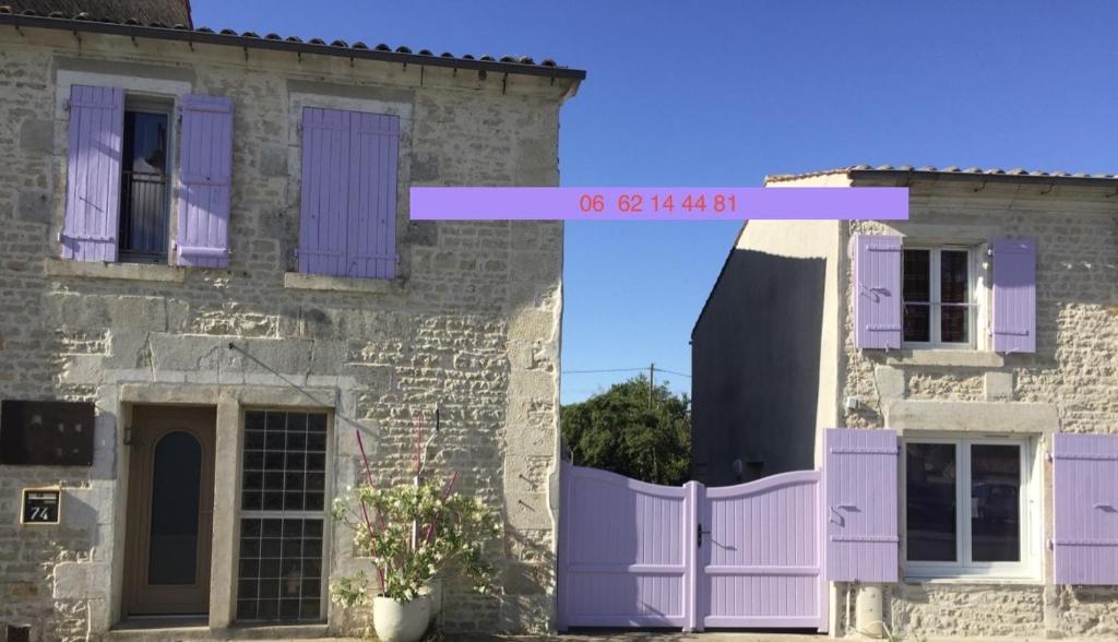 Ferrières阿卡西亚之家住宿加早餐旅馆的一座带紫色门和栅栏的老房子
